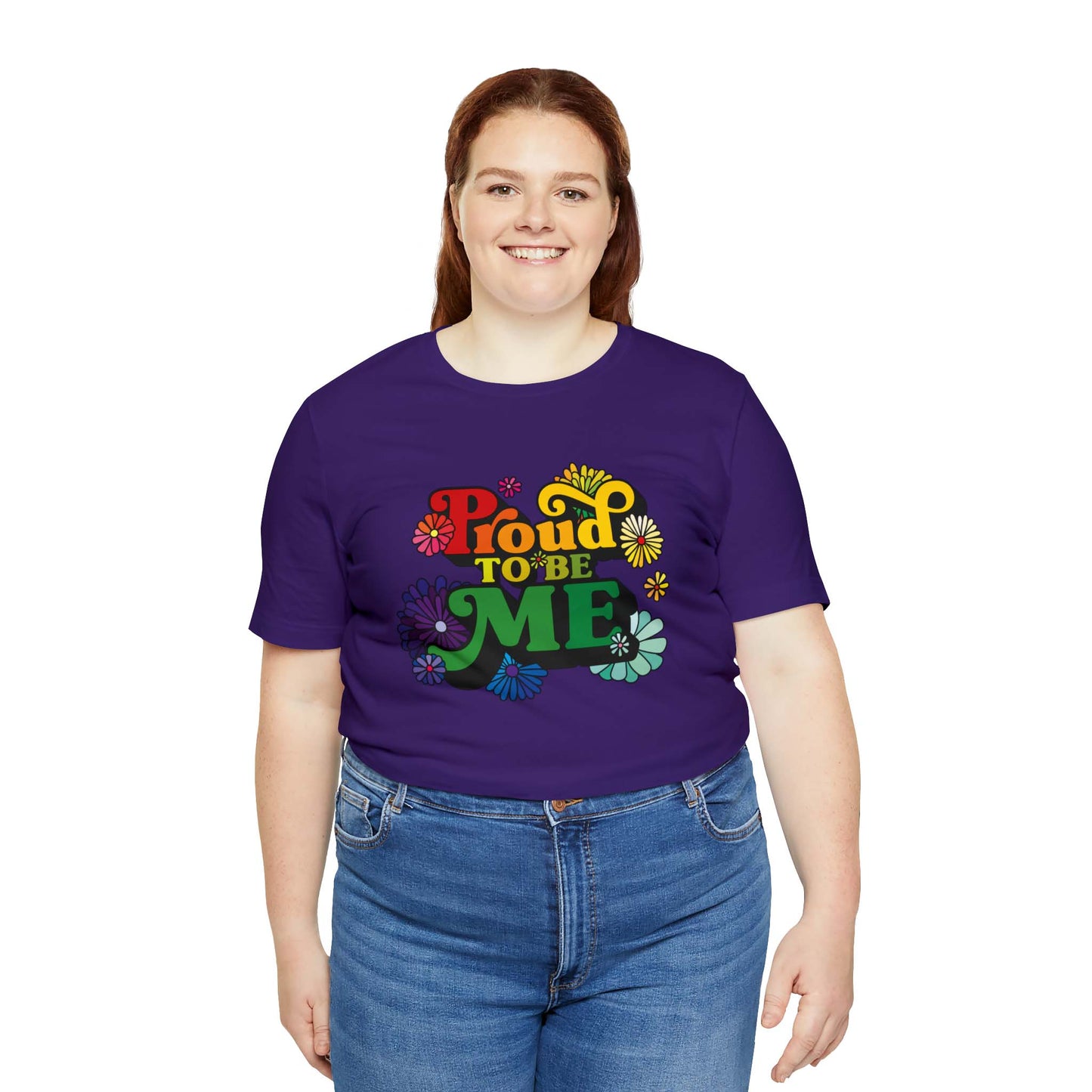 Purple T-shirt with colorful PROUD TO BE ME meme printed at the front of the women’s shirt. Meme is surrounded by colorful flowers.