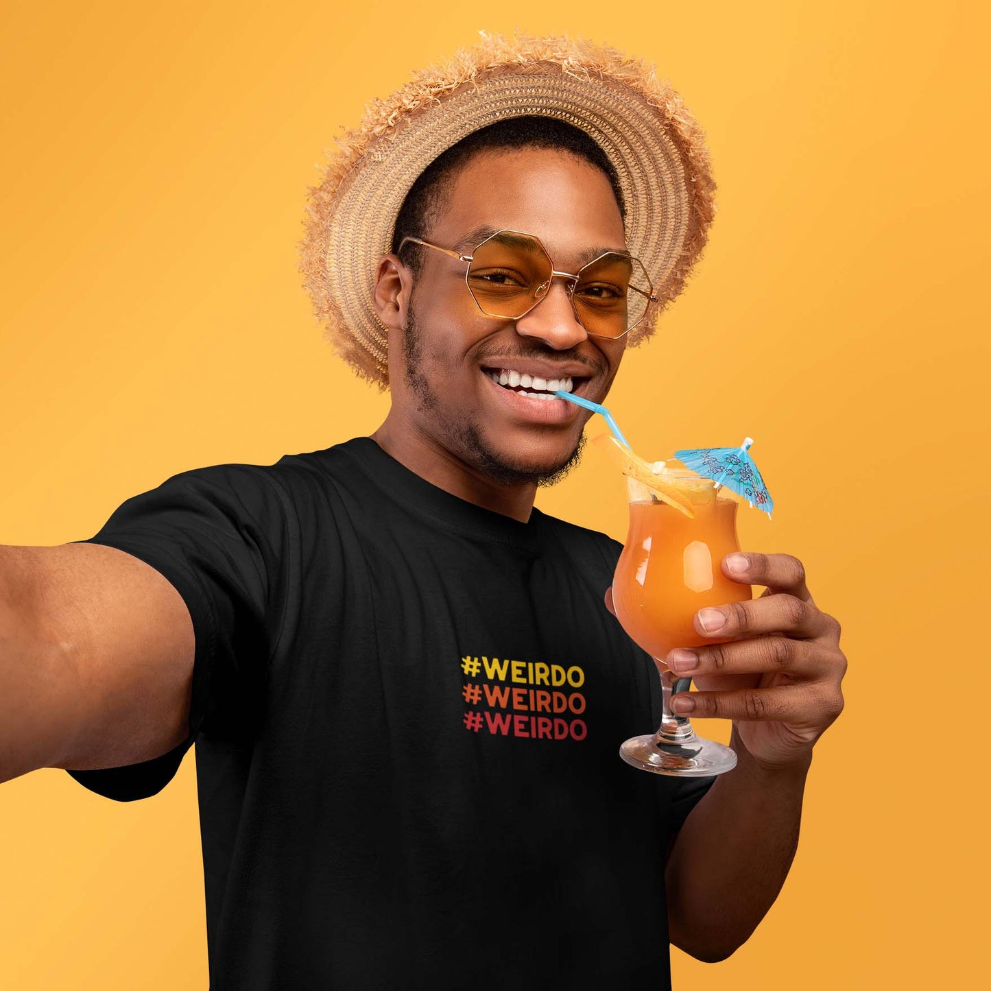 man drinking a cocktail and wearing a black t-shirt with #WEIRDO meme embroidery at the front of t-shirt. Alternative fashion brand for weirdos.