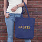 You can only shop with this shopping bag if you are a rebel! This navy blue tote bag has a liquid golden #REBEL meme visible at the front of the bag.
