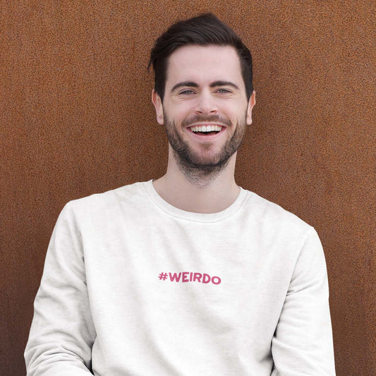 man wearing a white sweatshirt with pink #WEIRDO meme embroidery. alternative fashion brand for weirdos.