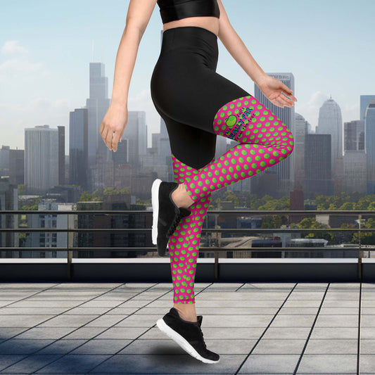 black yoga leggings, with pink at the bottom covered with green apples. funny meme: this apple falls really far from the tree shown on the right leg.